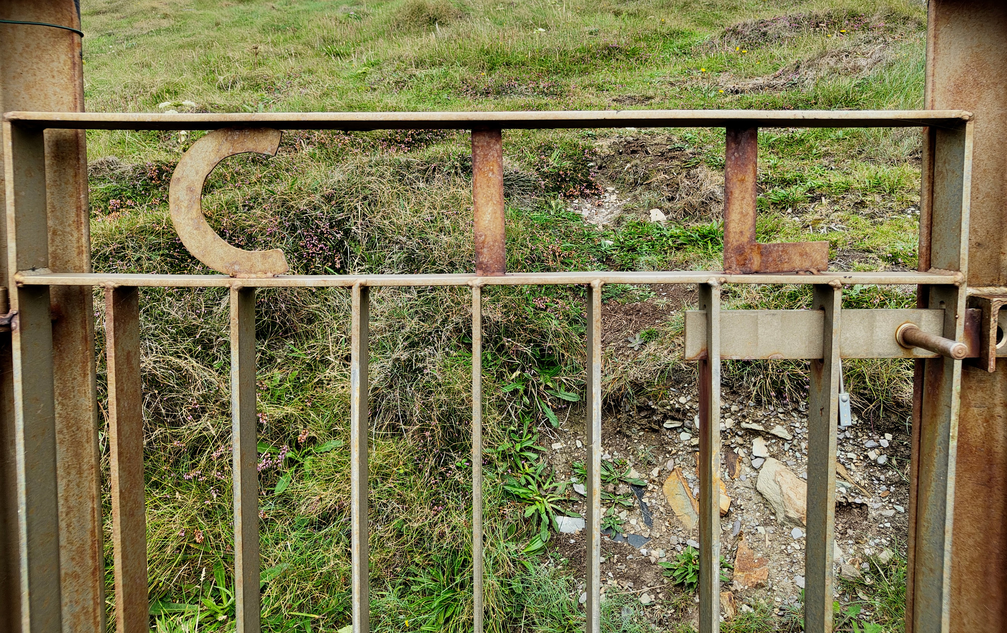 A rusted gate with the letters CIL integrated into the metalwork. CIL stands for the Commission of Irish Lights