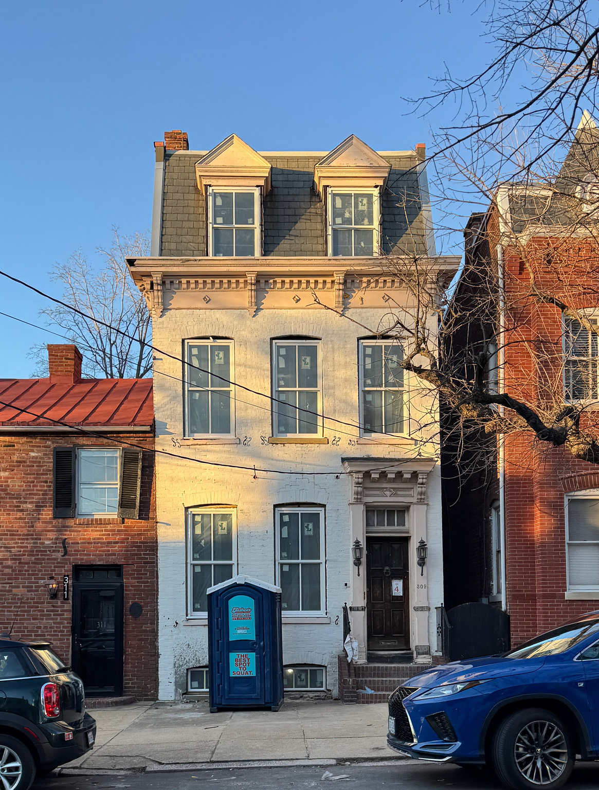 portapotty in front of a historic townhome with obvious construction happening inside