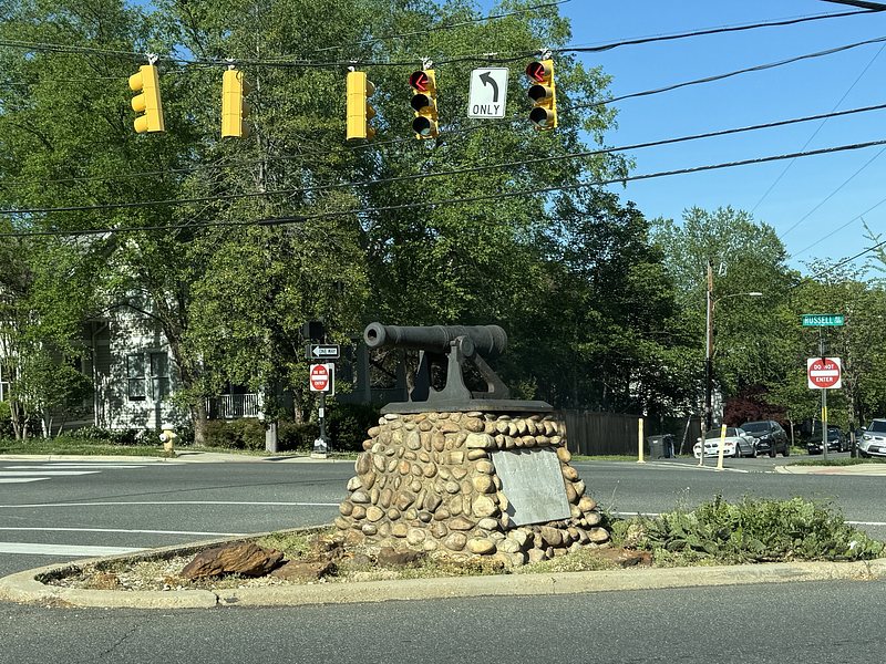 Braddock road cannon. cannon mounted on a stone pedestal on a small triangle in the middle of a busy road intersection. 