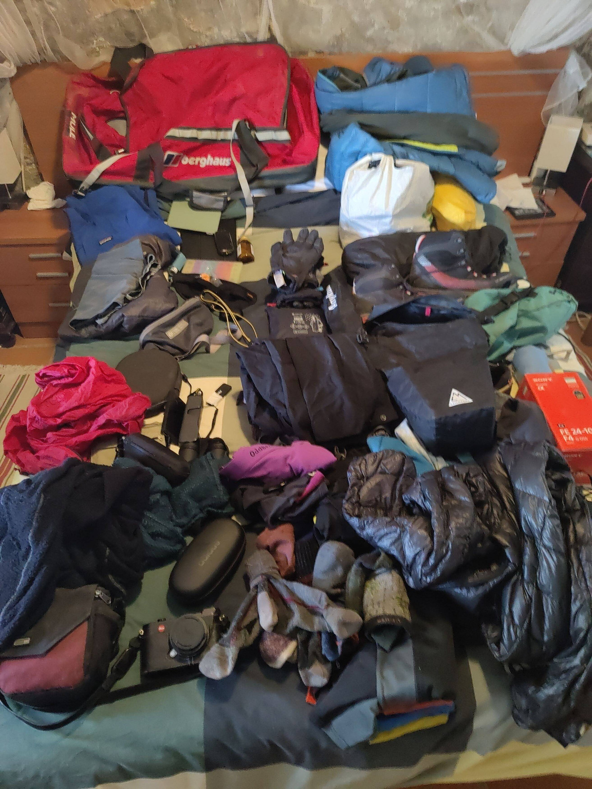 A load of mountain clothes strewn on a bed