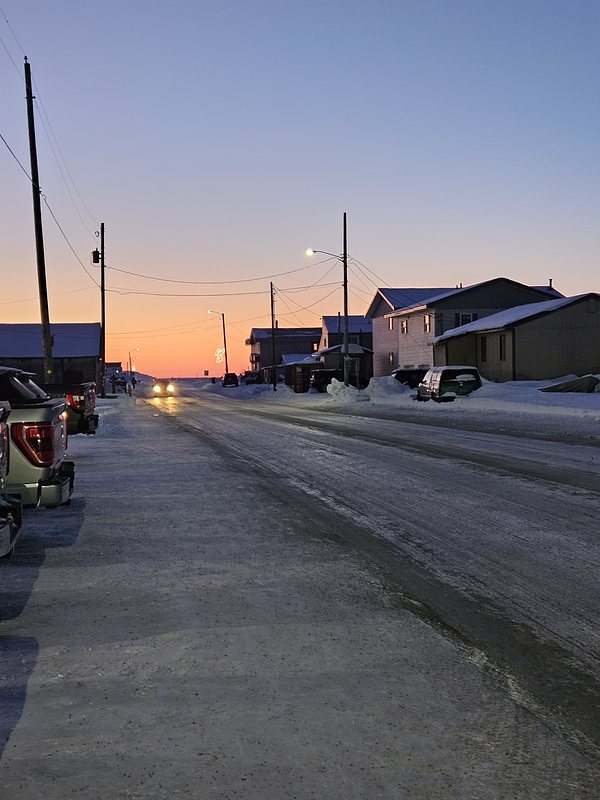 A picture of a quiet street and the sunrise in the background.