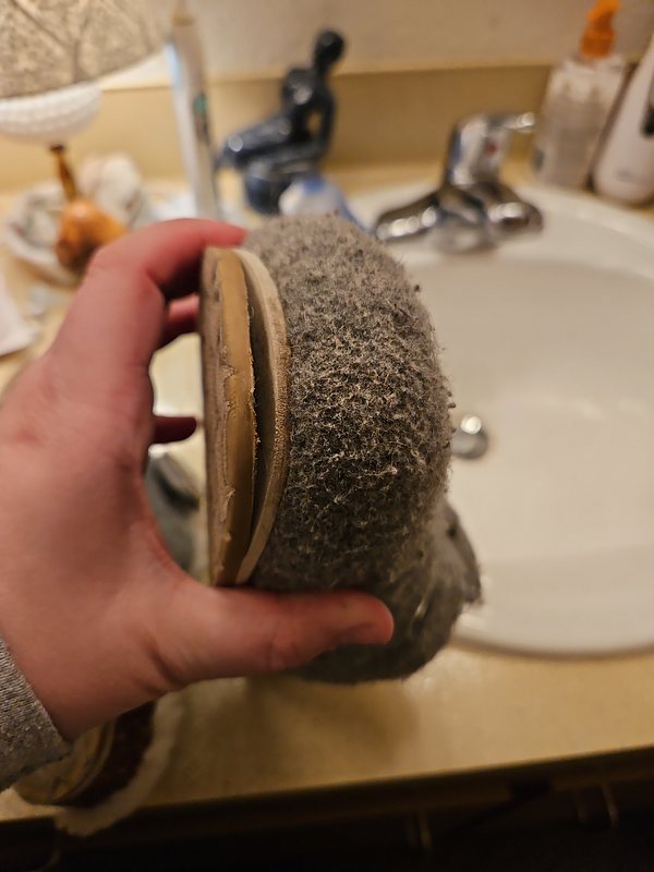 Picture of a hand holding a slipper with a broken sole.