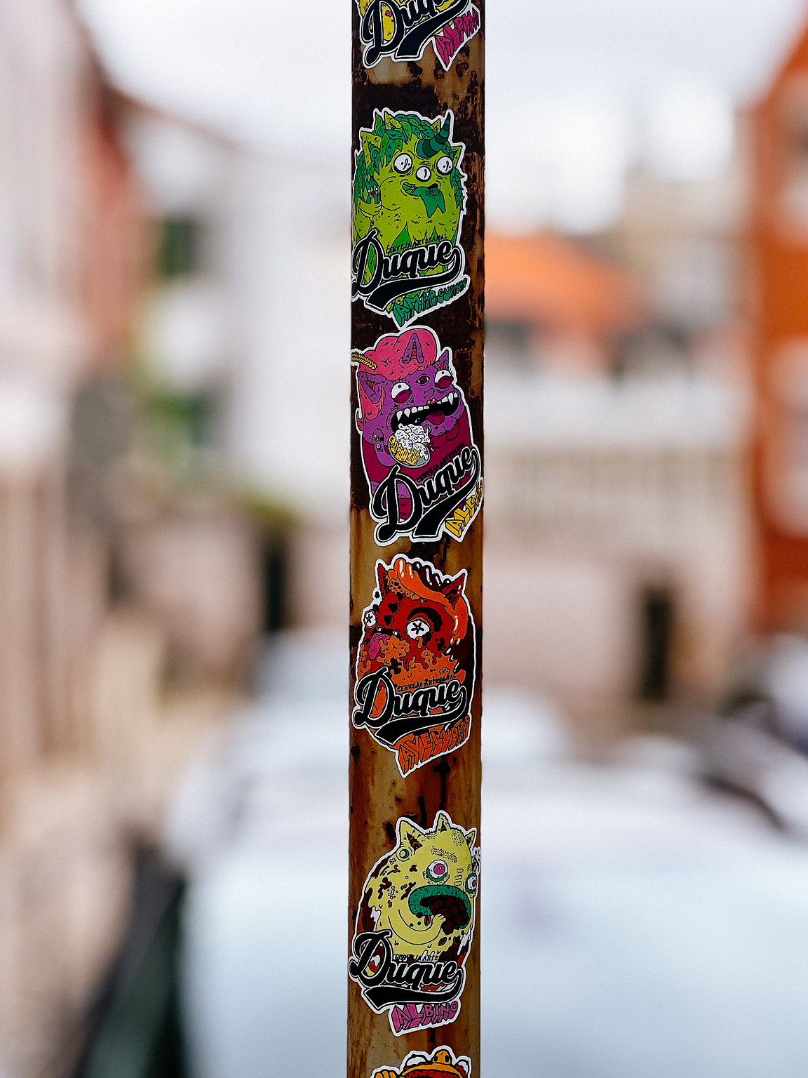 Multiple colorful stickers on a pole. 