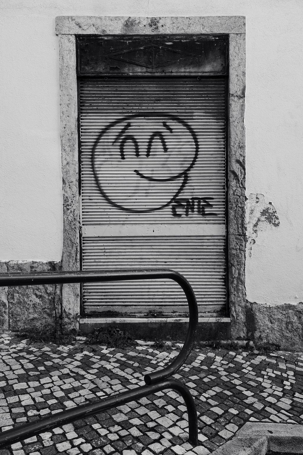 A smiling face graffitied on a door.