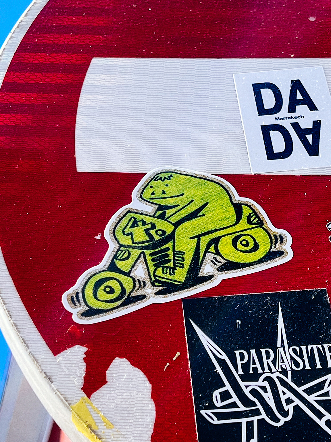 A green creature riding a green motorcycle. A sticker. 