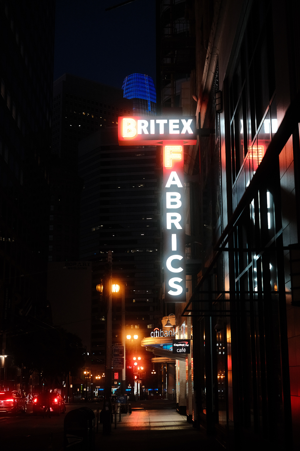 A white and red neon sign that reads "Britex Fabrics"