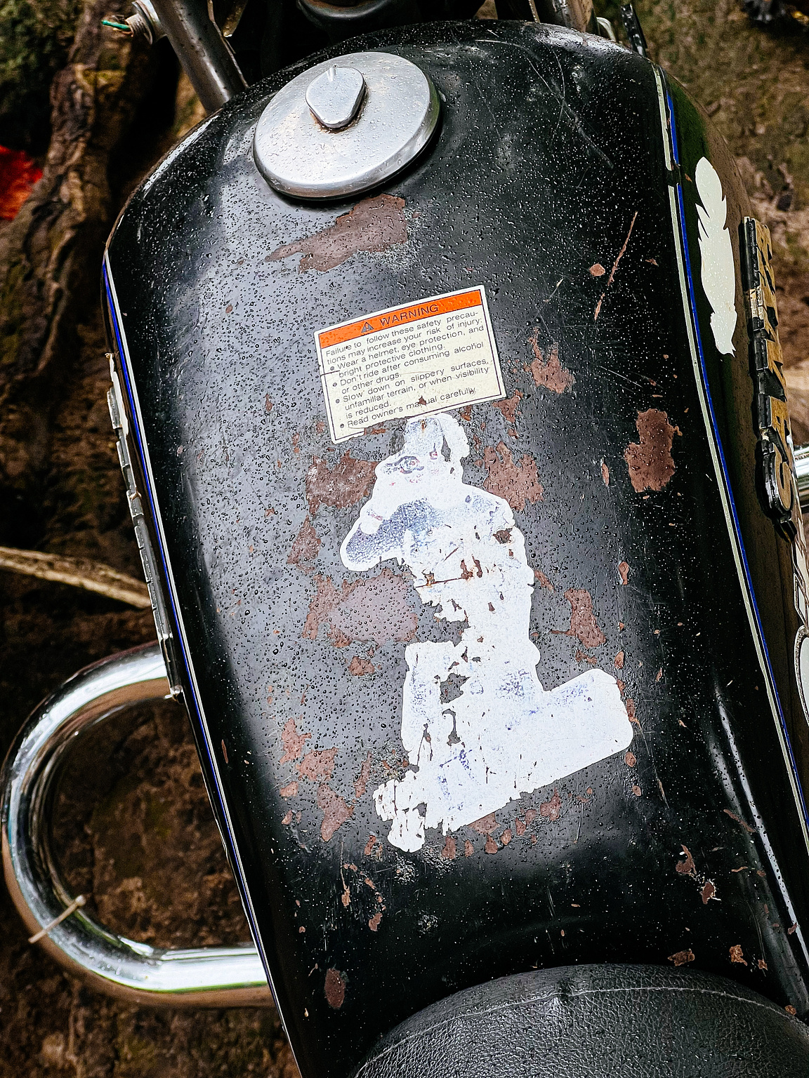 Faded sticker on a motorcycle's gas tank. 