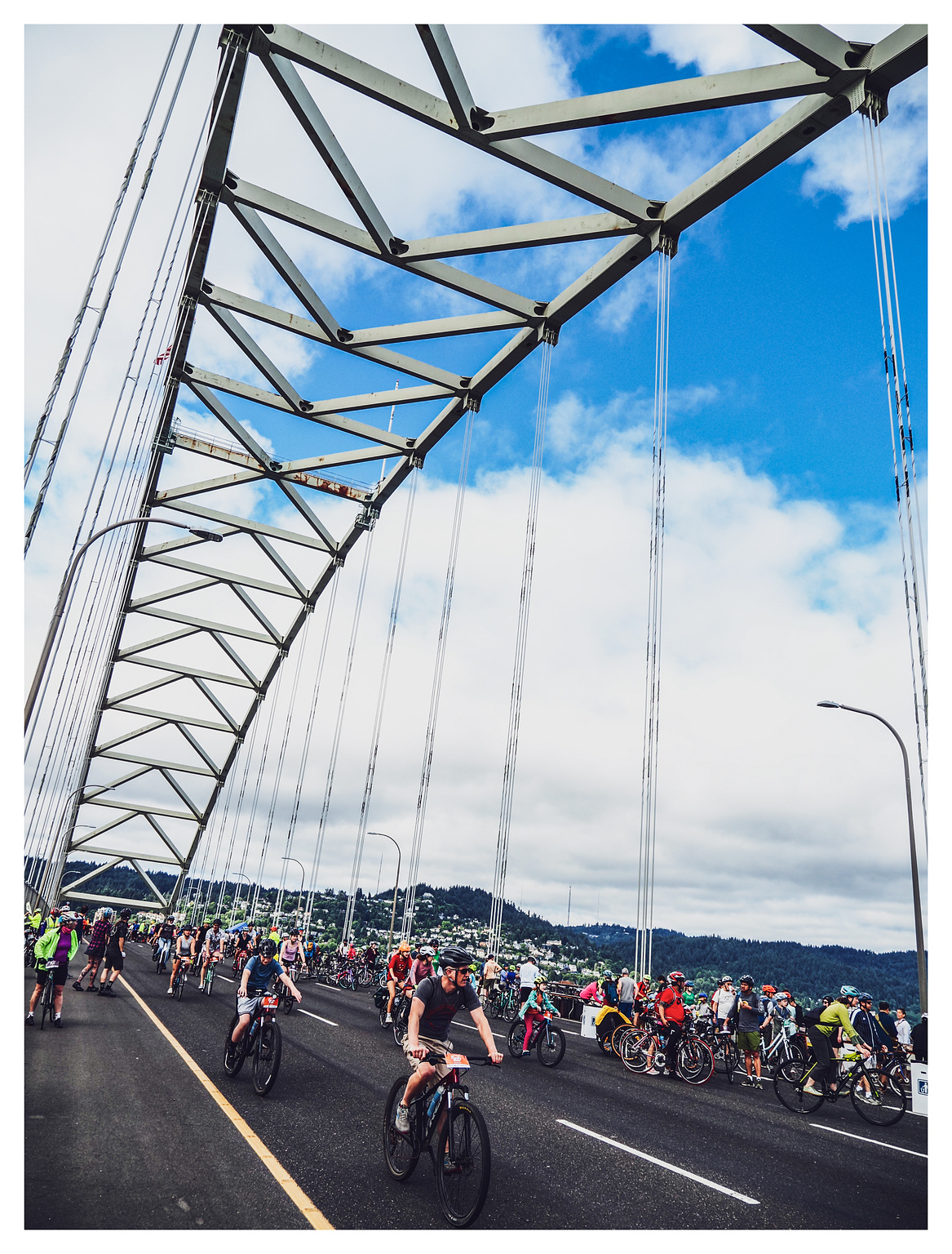 Bicyclists pedaling along a closed highway bridge. 