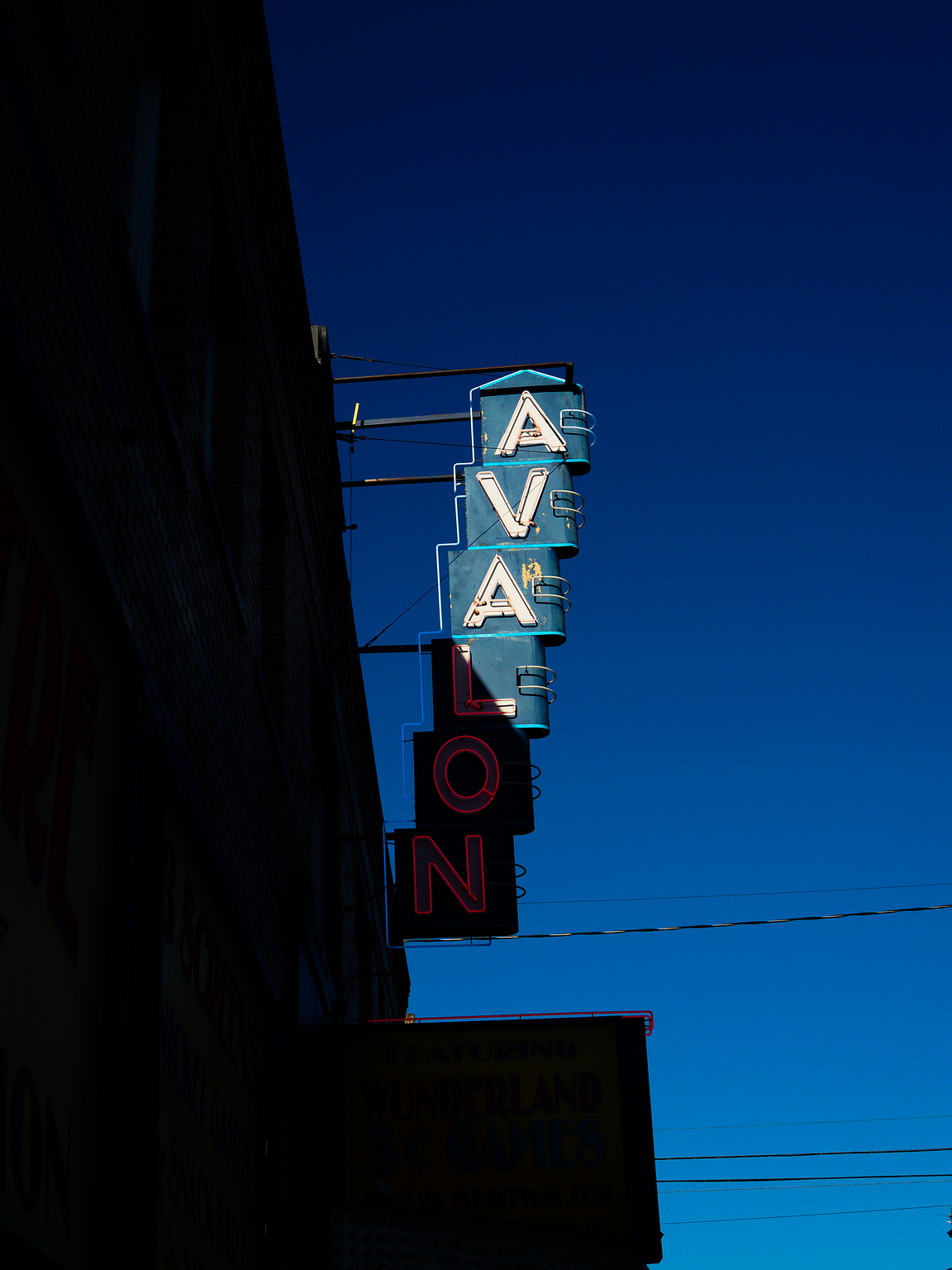 A vintage blue neon sign that reads "Avalon" 