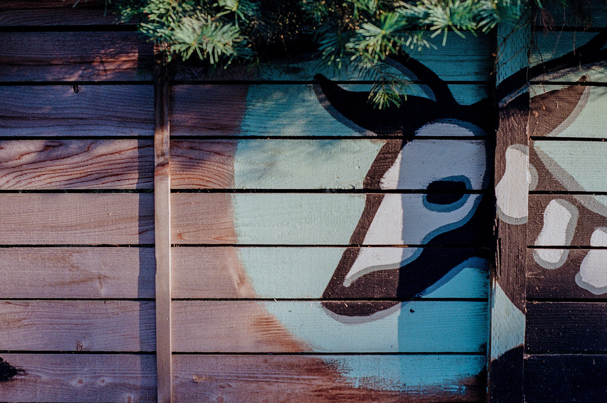 A stylized deer skeleton painting on a wooden fence