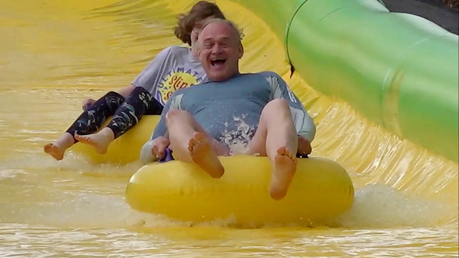 Ed Davey on a water slide laughing