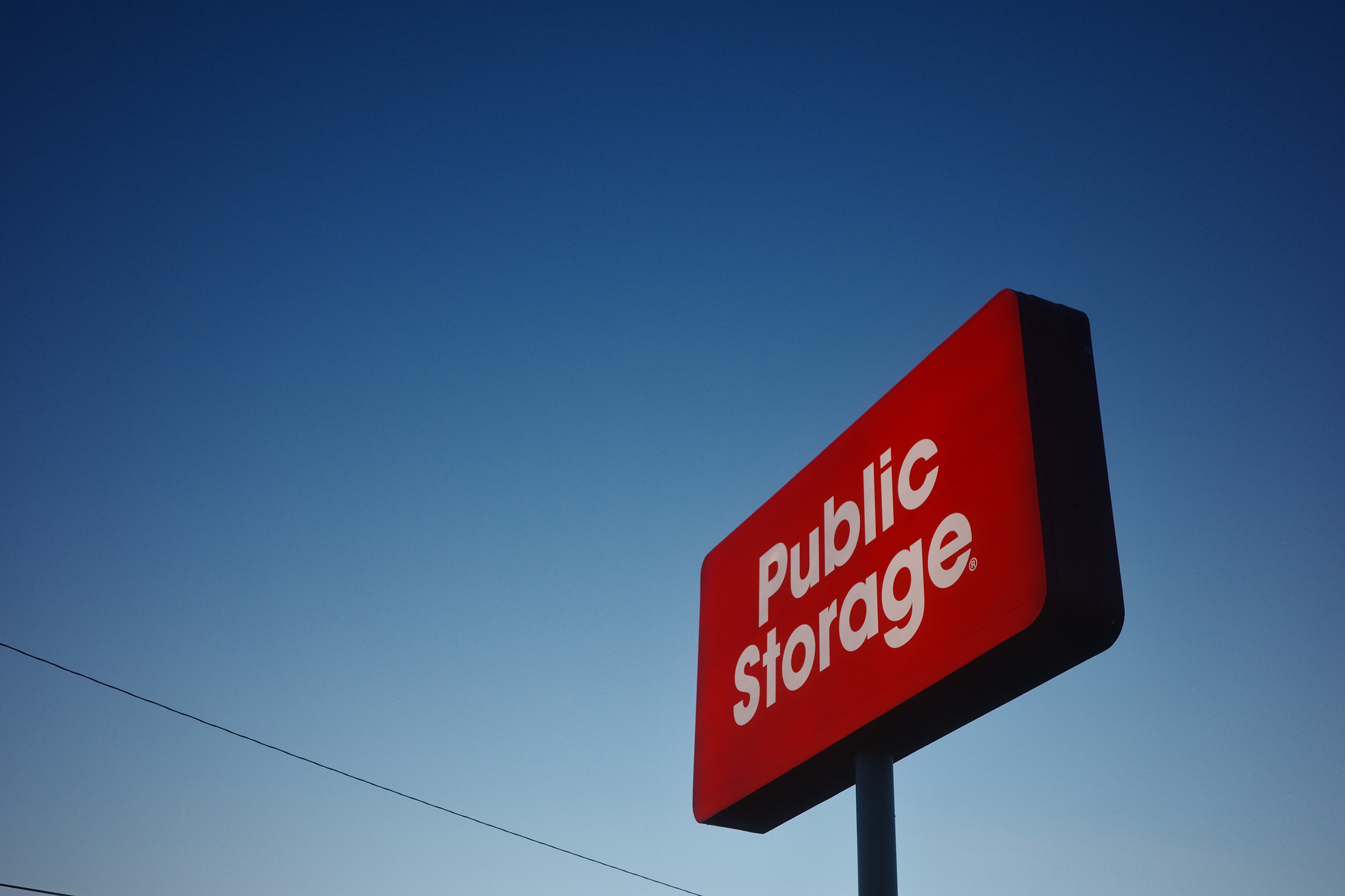 Bright red sign against a blue sky with the words "Public Storage"