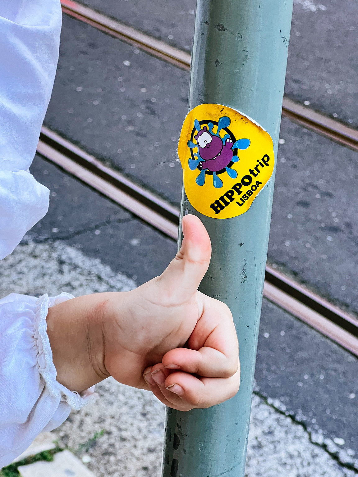 A child's hand near a sticker. 