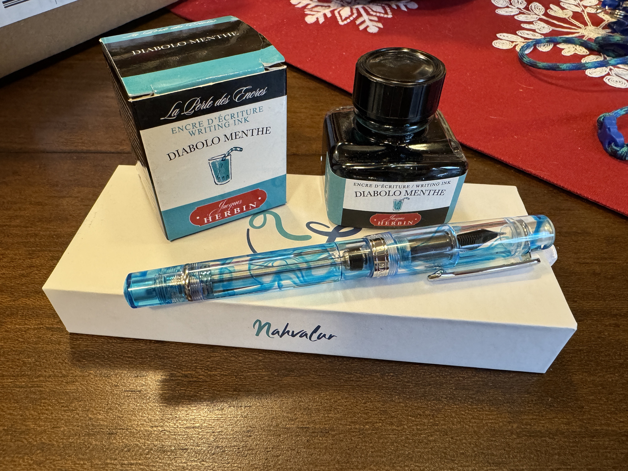 blue and transparent fountain pen, bottle of ink labeled "diabolo menthe", and the boxes for each