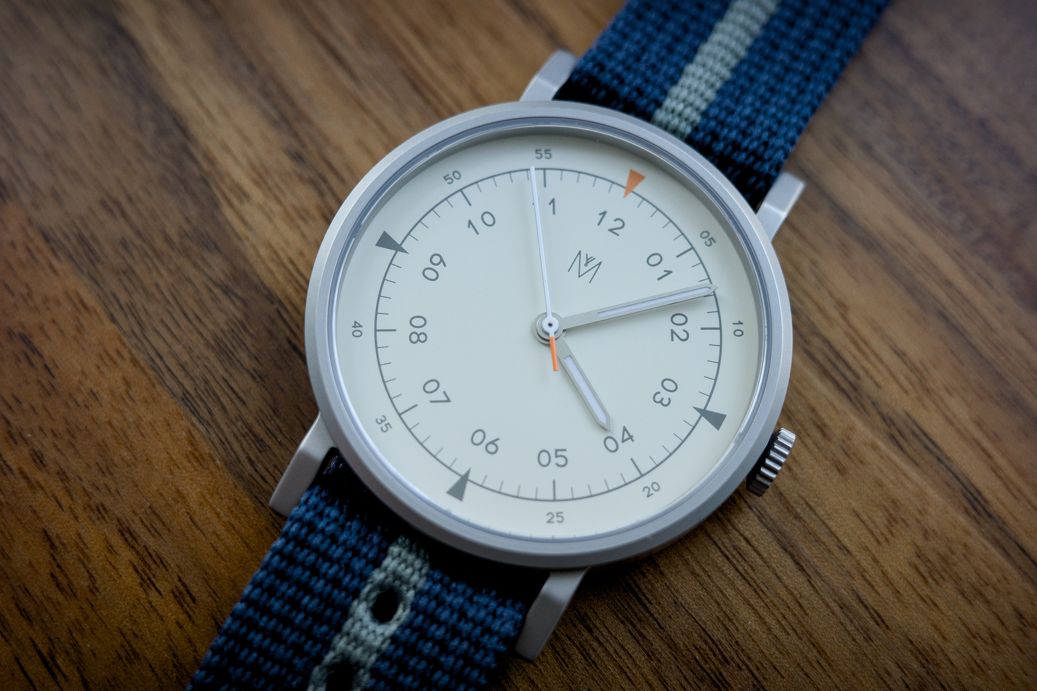 Close-up of the Maven watch's dial, with a blue strap framing the white face and grey dial markings.