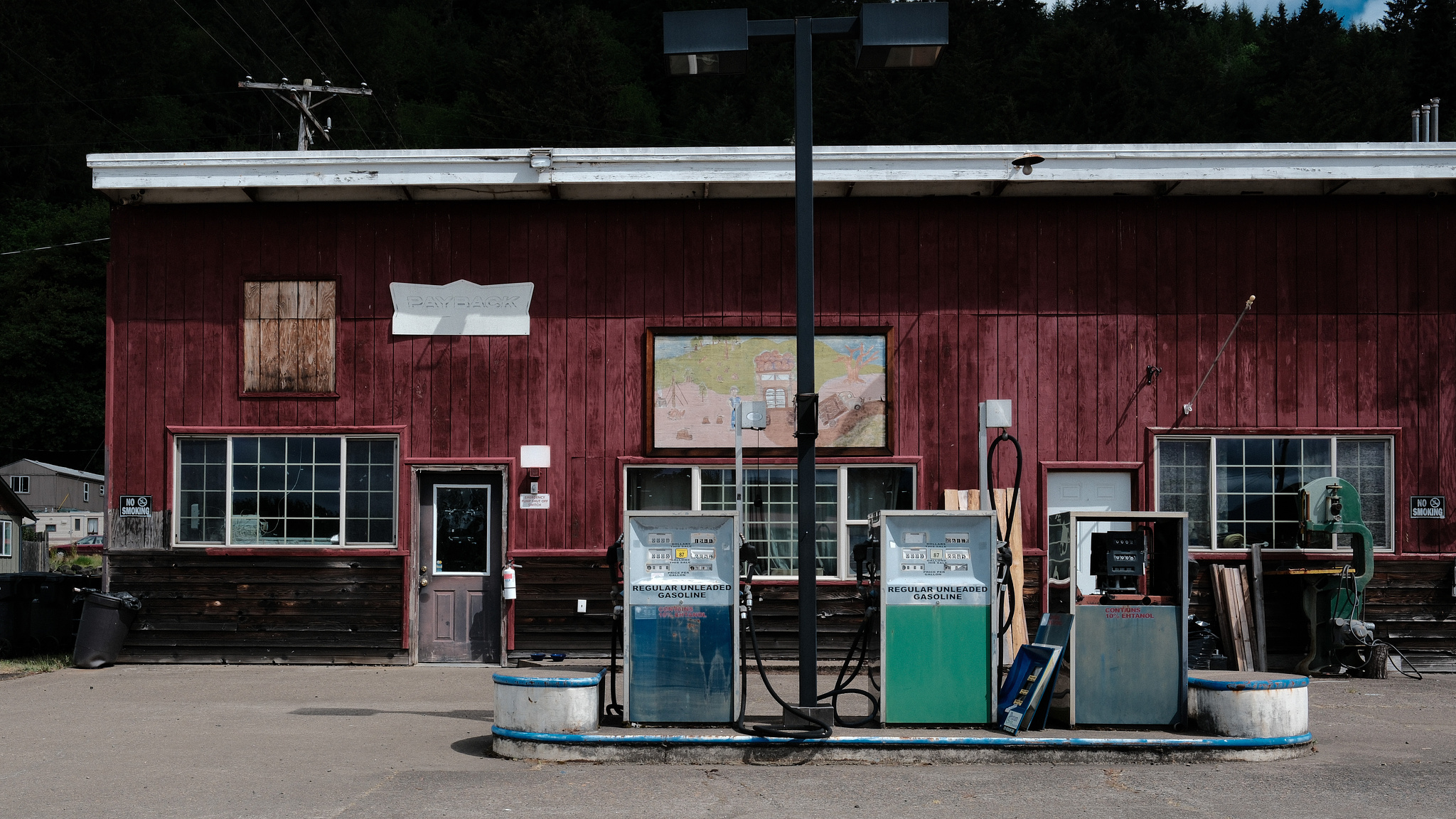 Gas pumps in front of a decrepit gas station. 