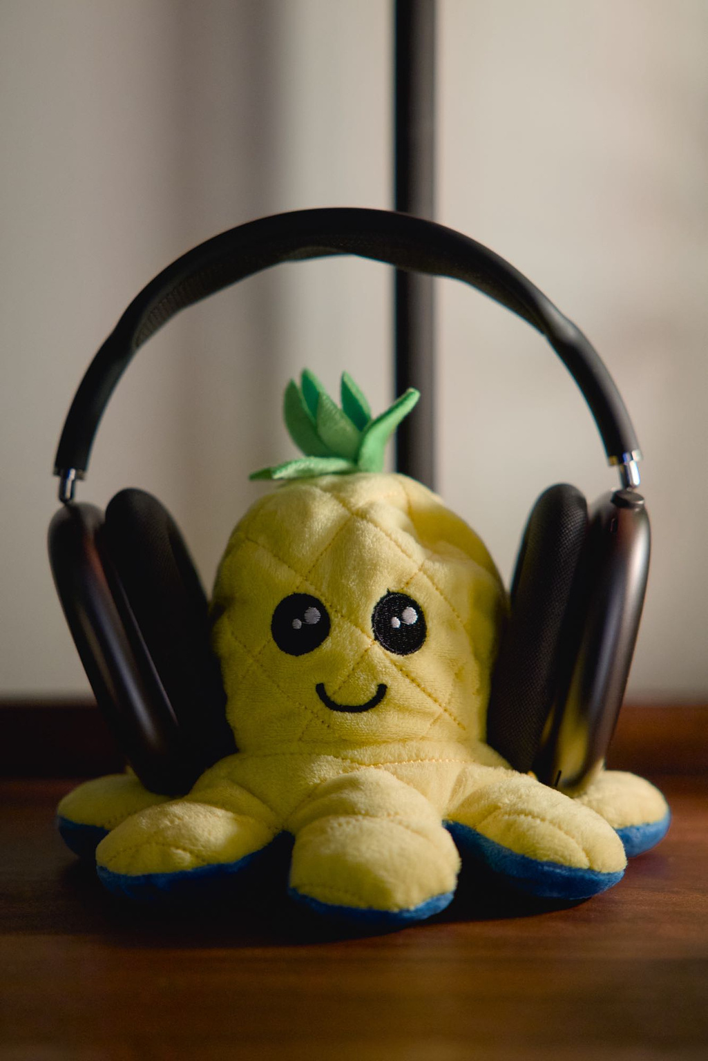 AirPods Max being "worn" by a yellow octopus plushie.