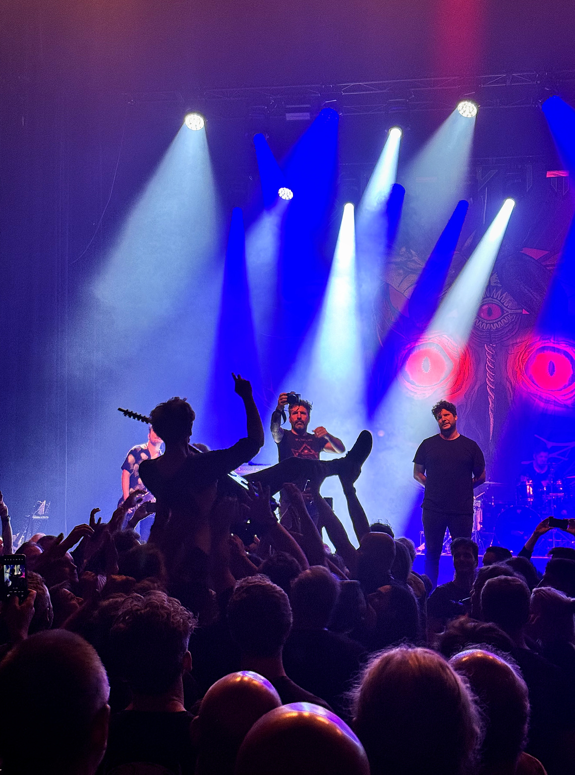 Gitarist die met zijn gitaar mee gaat crowd surfen