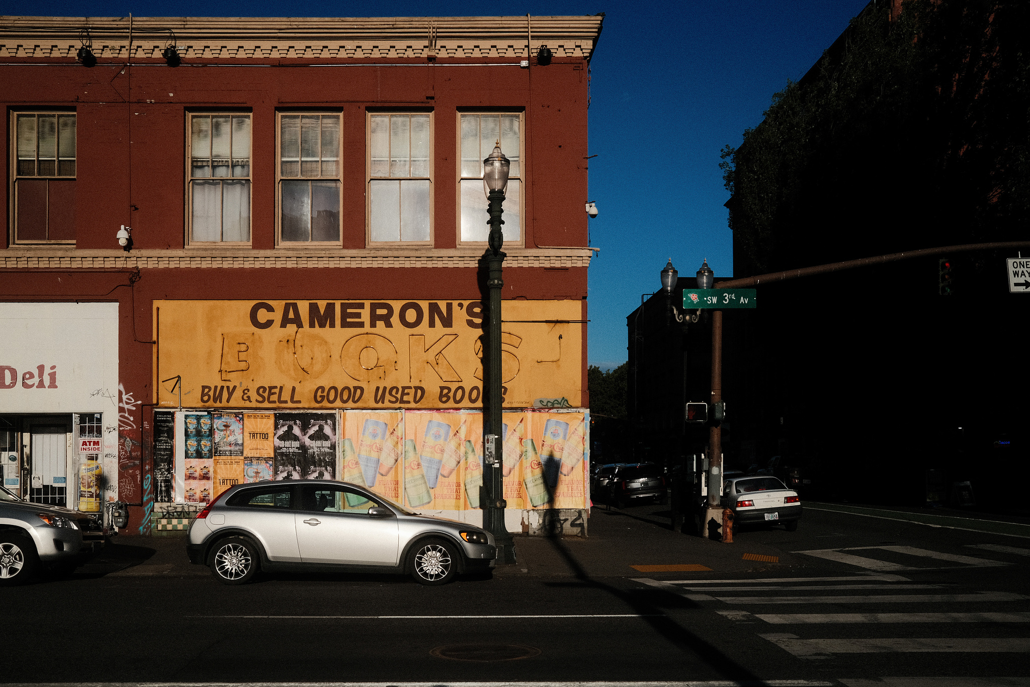 A weathered yellow storefront in low evening light reading "Cameron's Books"