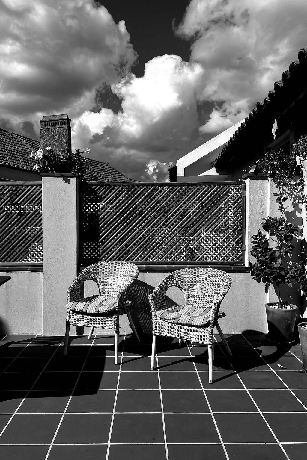 two chairs in a patio. dramatic clouds. 