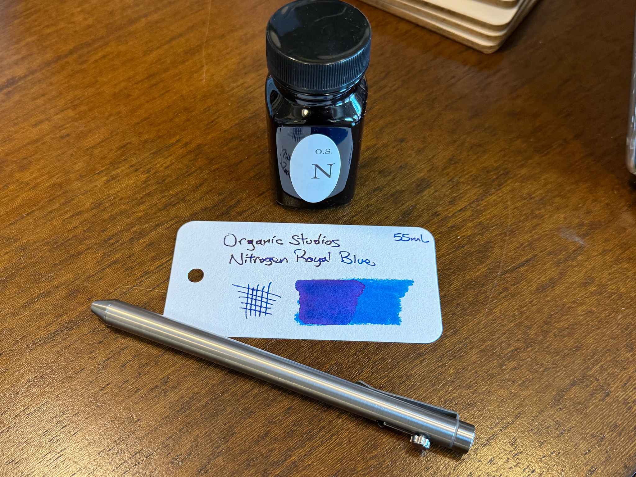 Ink bottle, titanium fountain pen, and small paper with ink sample