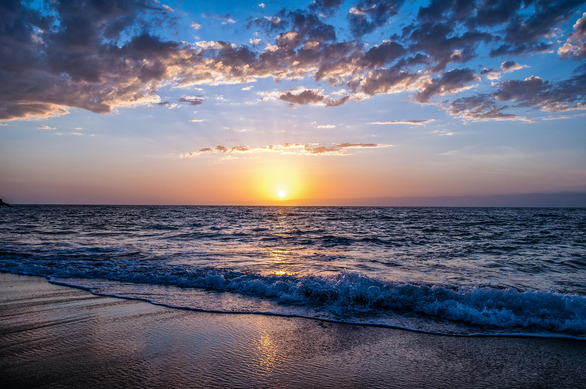 Beach during sunset with soft waves hitting the sand