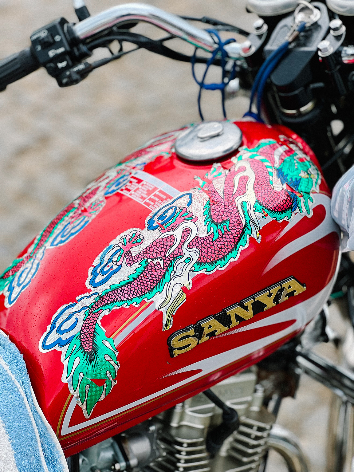 A dragon sticker on a motorcycle's gas tank. 