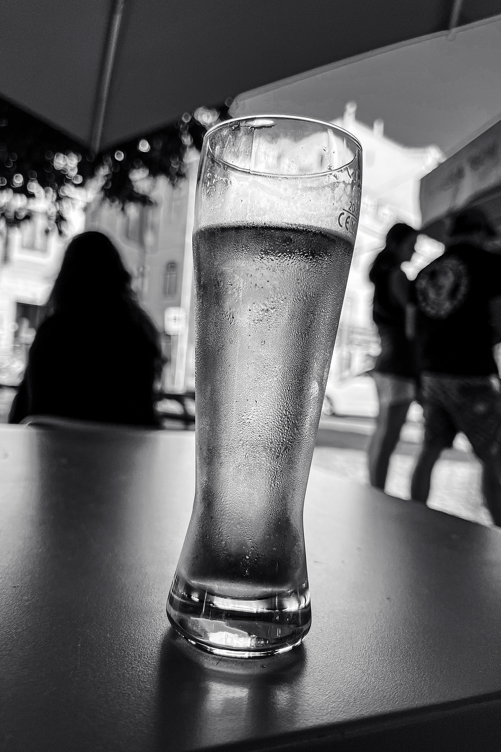 Beer glass. People in the back, out of focus. 