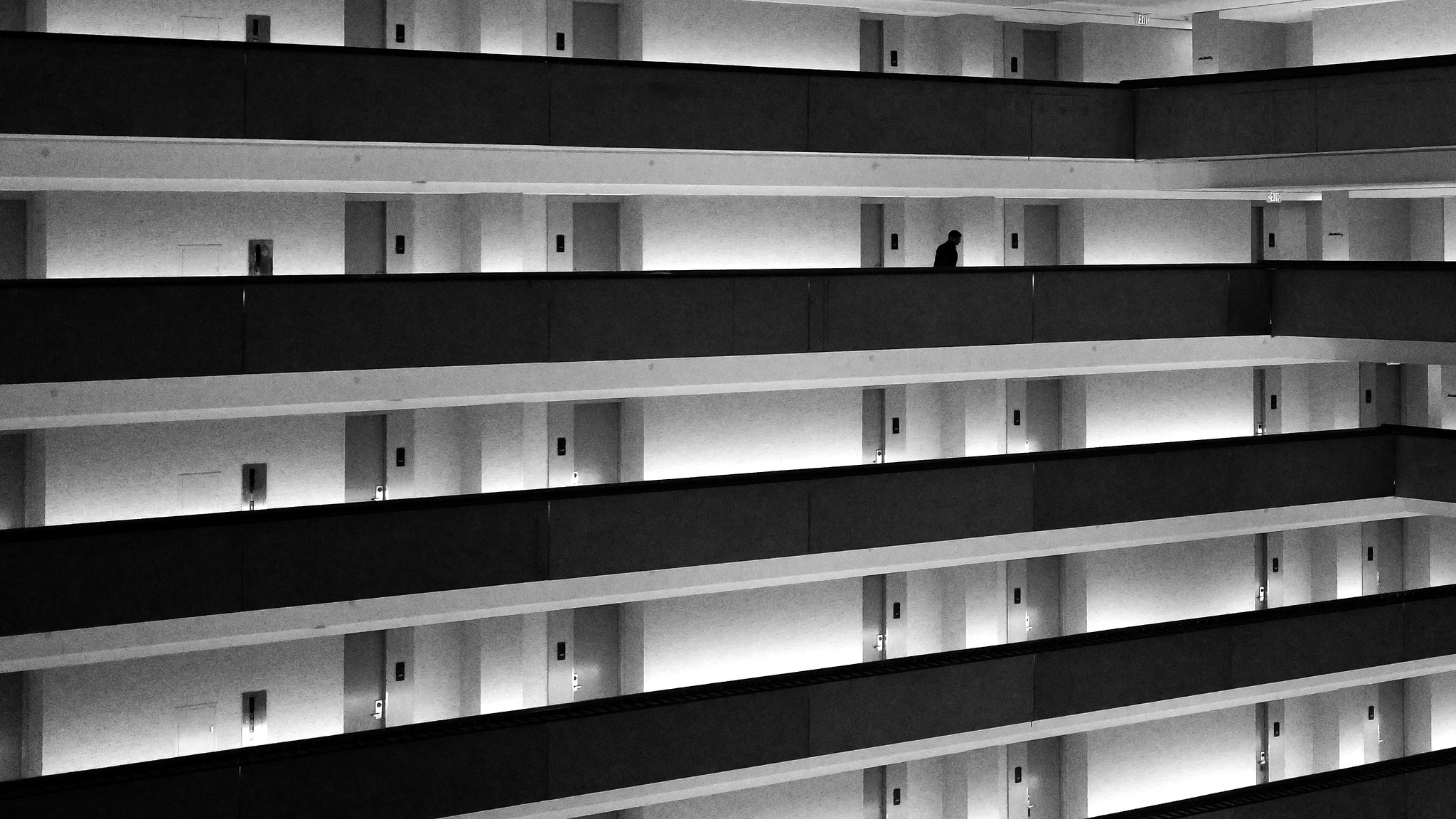 Monochrome .. a person in silhouette makes their way along an internal balcony in a hotel