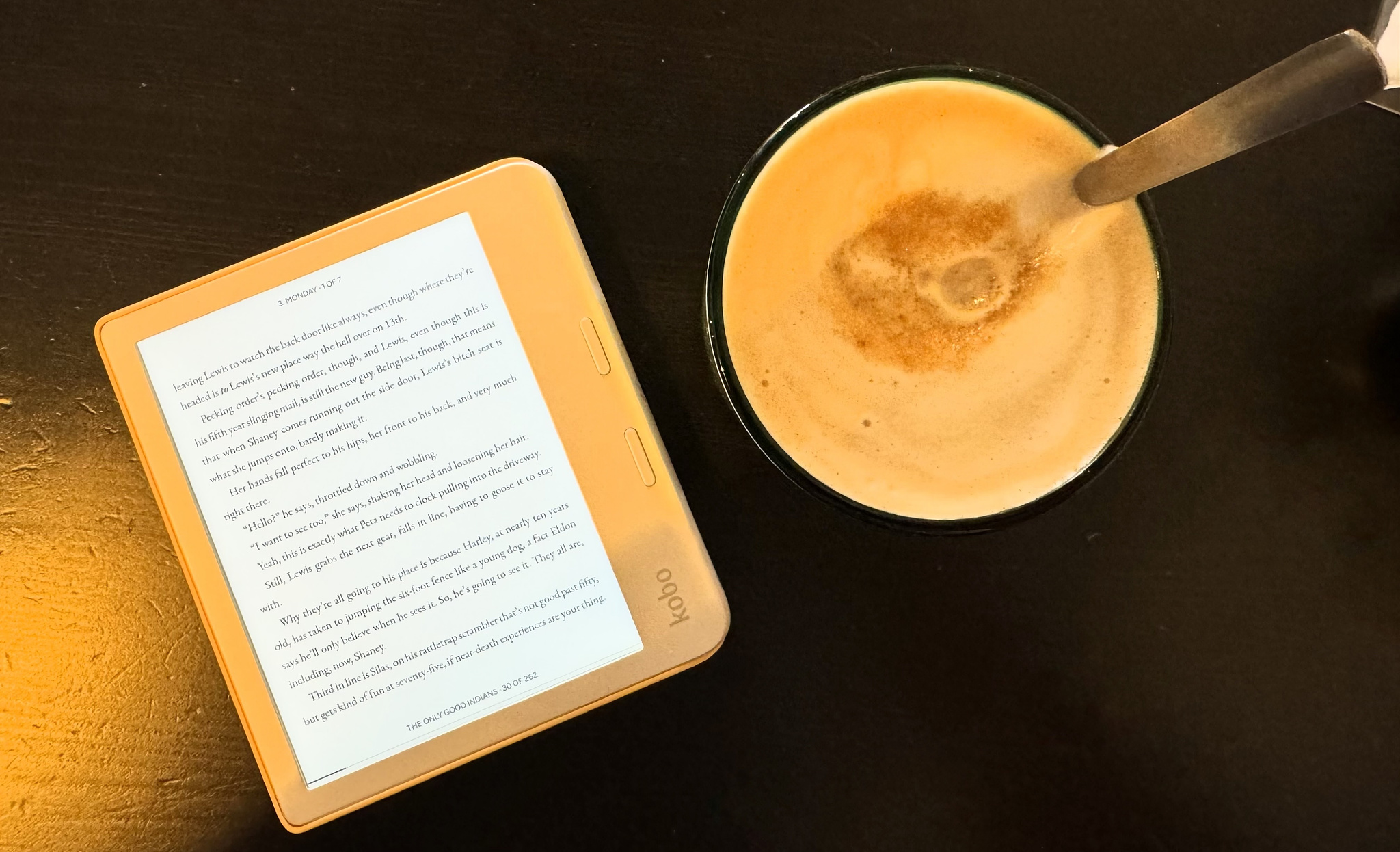 The Kobo Libra Colour on a table, next to a coffee