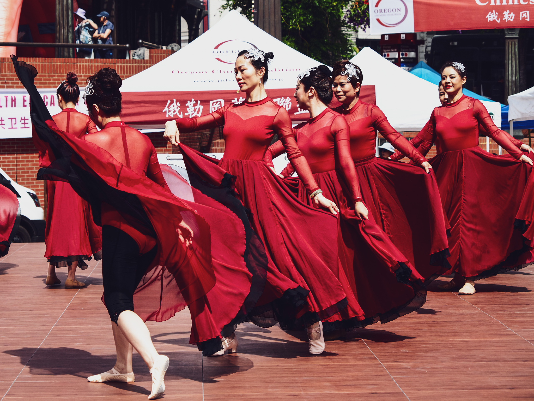 A line of Chinese dancers in bright red dresses