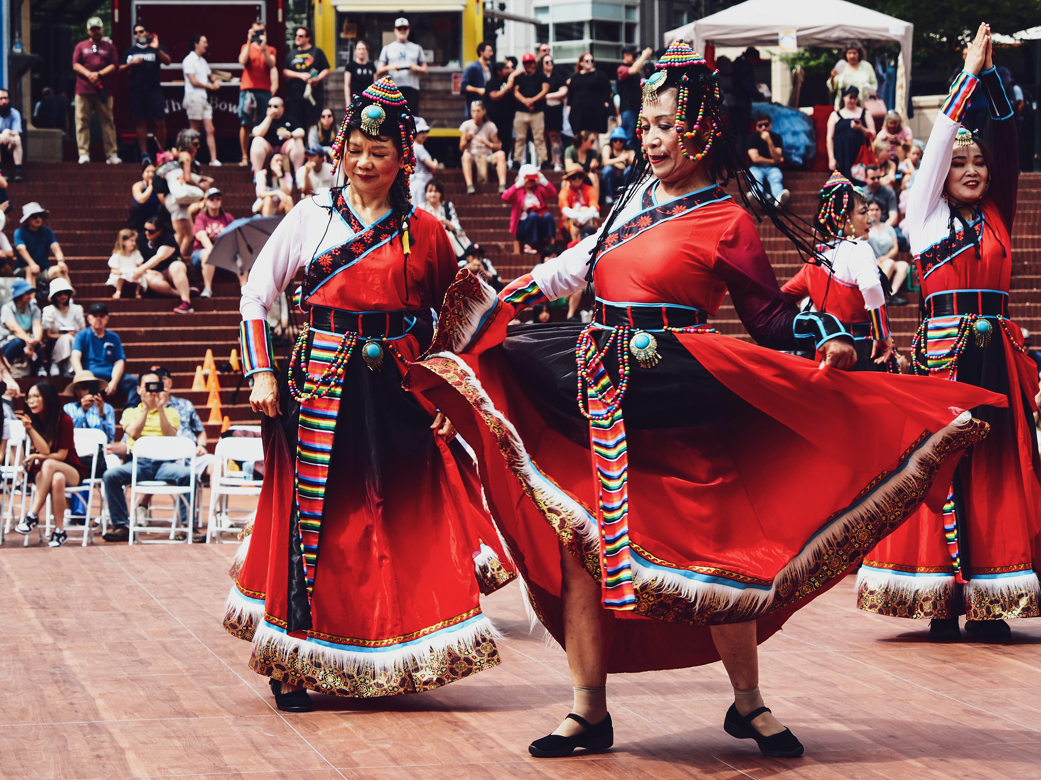 A Tibetan dancer in a bright red dress twirls