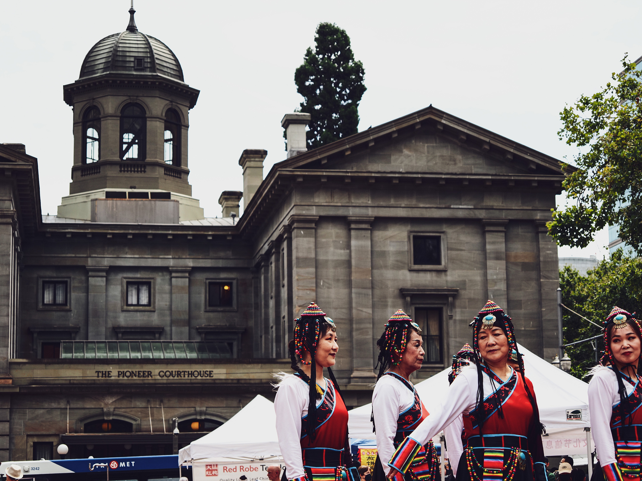 Four Tibetan dancers get ready to perform  in front of Pioneer Courthouse Square