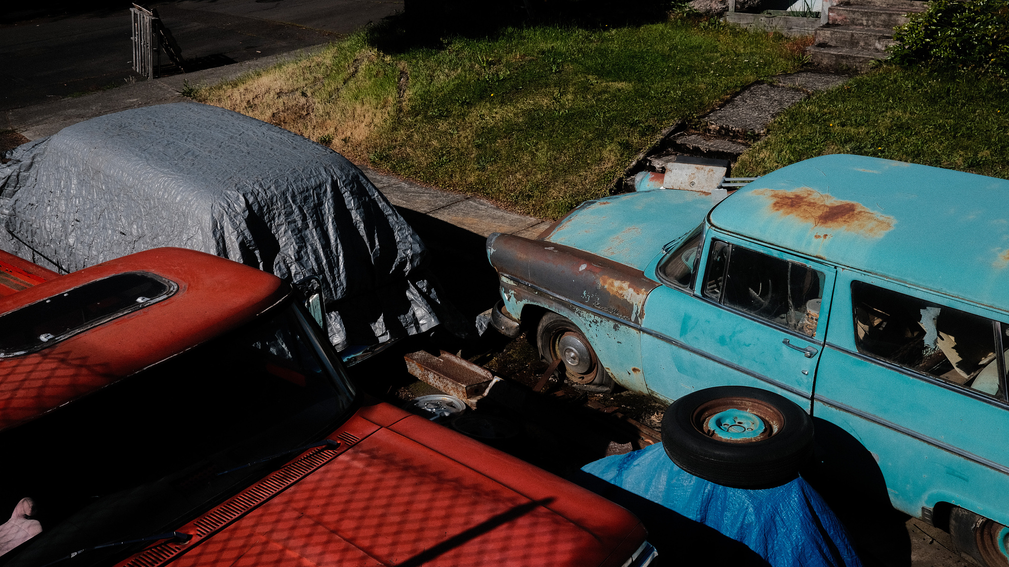 A bright red vintage pickup truck and a bright blue vintage station wagon