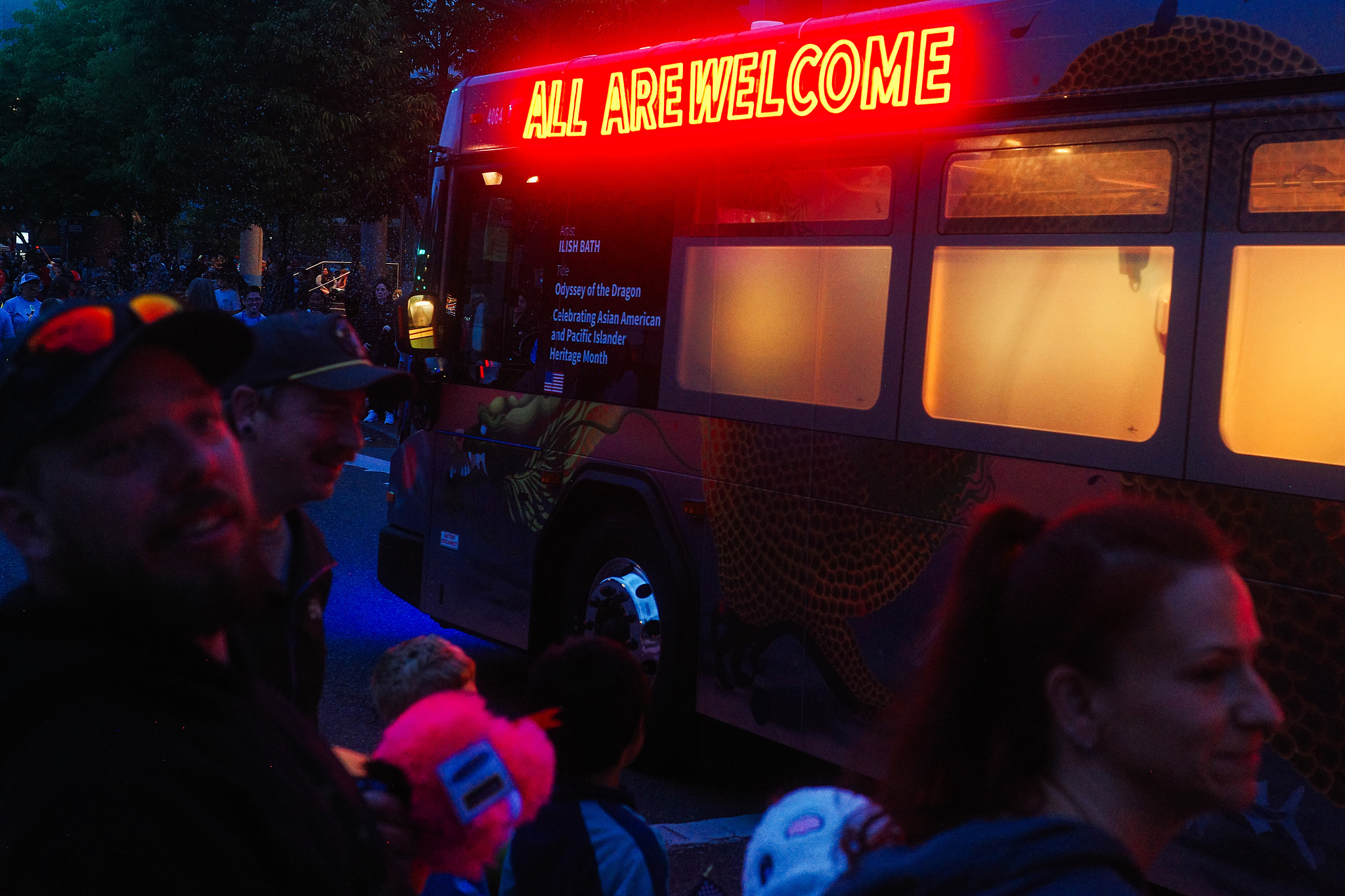 Trimet Bus with a red neon "All Are Welcome" sign. 