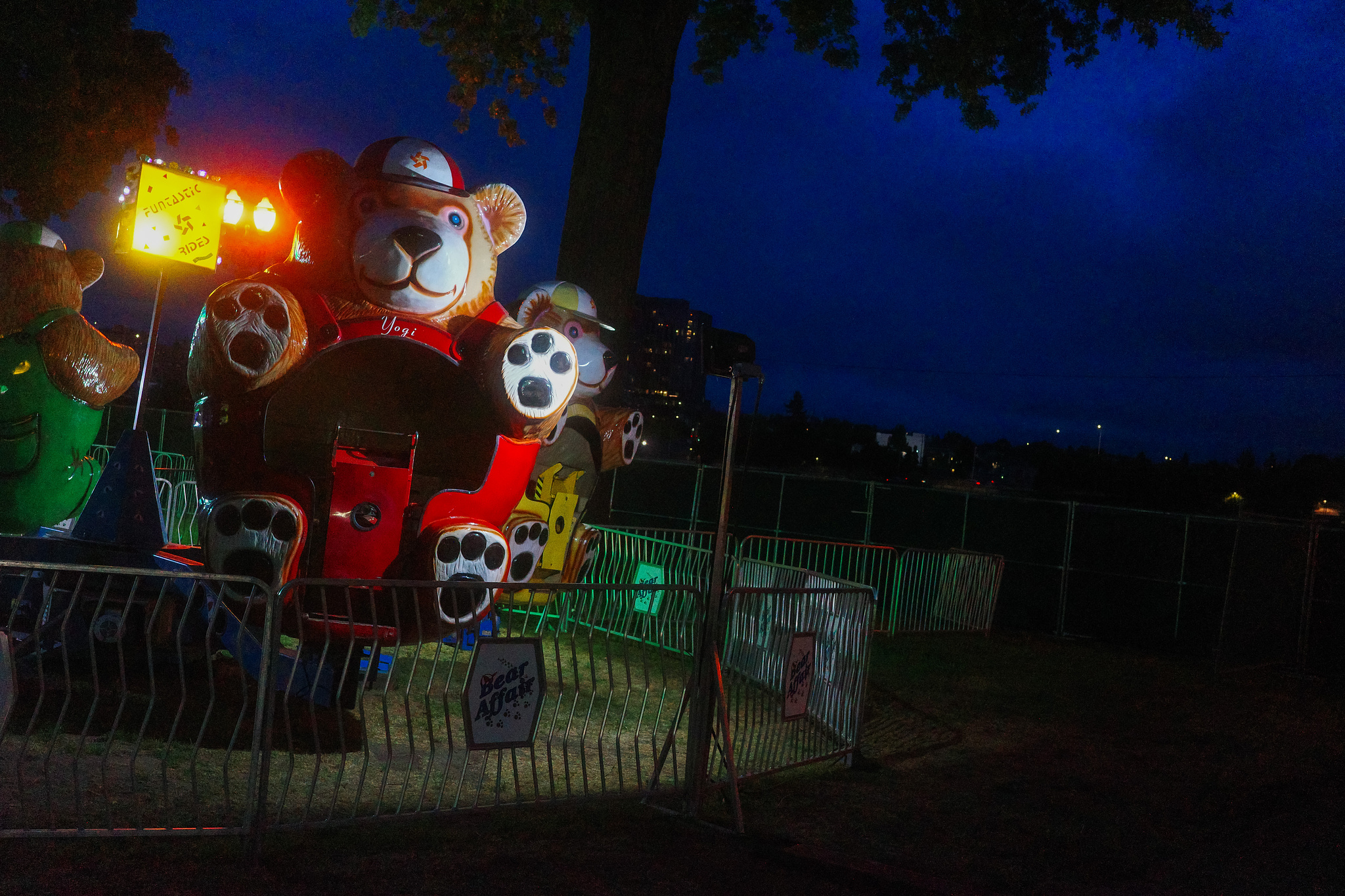 A kid's ride at a carnival. The cars are shaped like bears. 