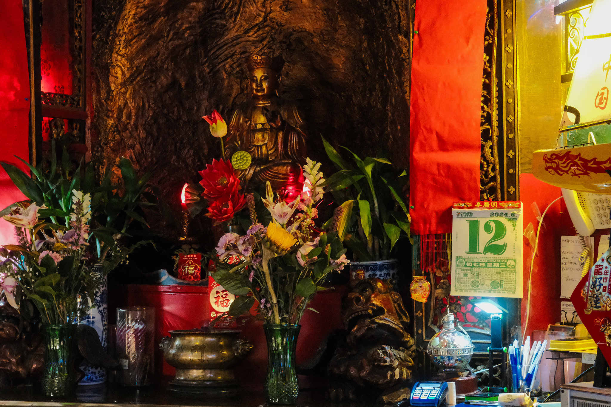 A Chinatown bar with a golden statue in a shrine 