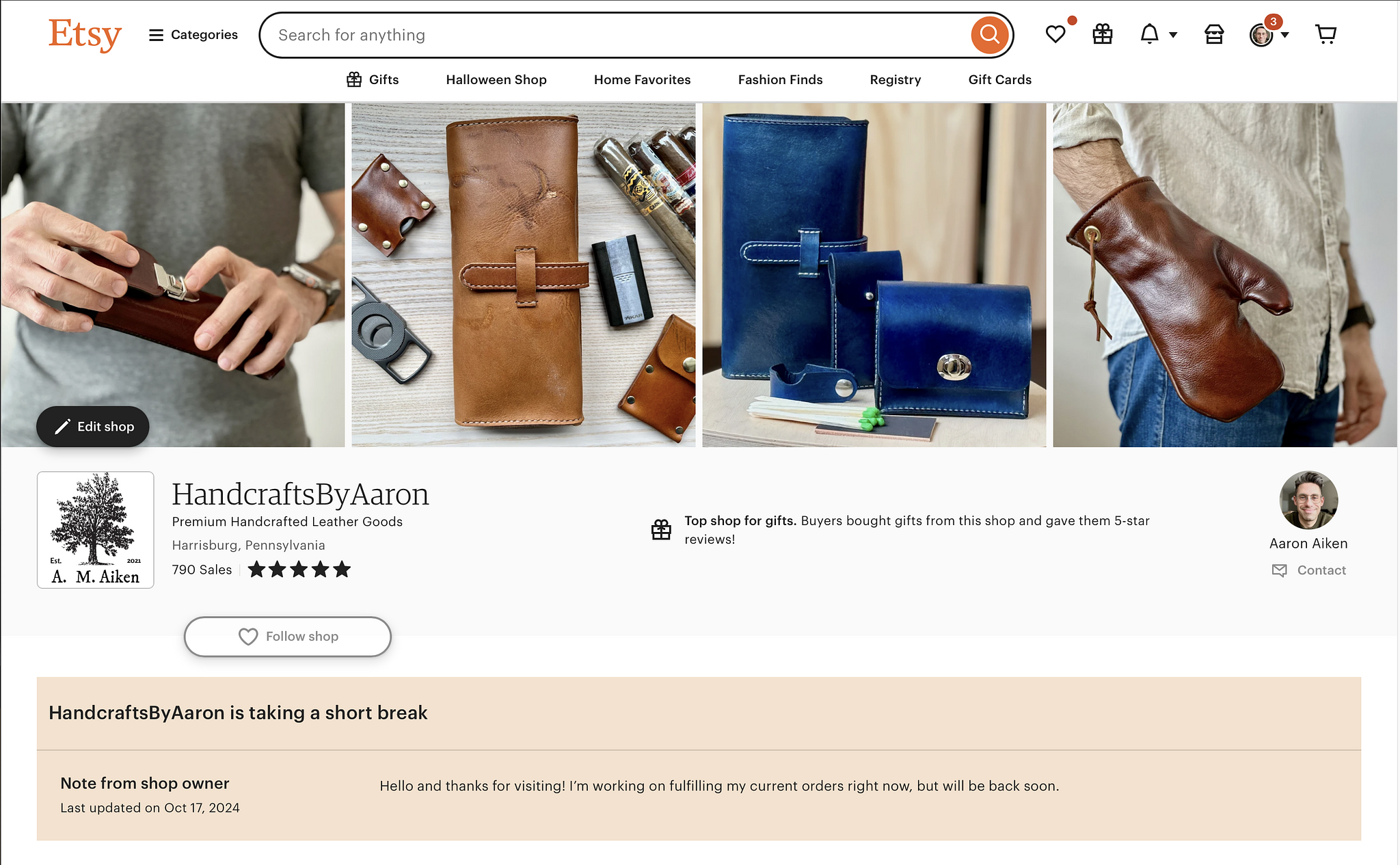 Screenshot of an Etsy shop page for “HandcraftsByAaron,” featuring premium handcrafted leather goods. The shop is based in Harrisburg, Pennsylvania, with 790 sales and a five-star rating. The banner shows several leather products, including wallets, pouches, and a leather oven mitt, all in warm tones of brown and blue. The shop has a notice stating “HandcraftsByAaron is taking a short break,” with a message from the owner explaining they are currently fulfilling orders but will be back soon. The shop owner, Aaron Aiken, is shown in the profile image, and there is an option to contact the owner.