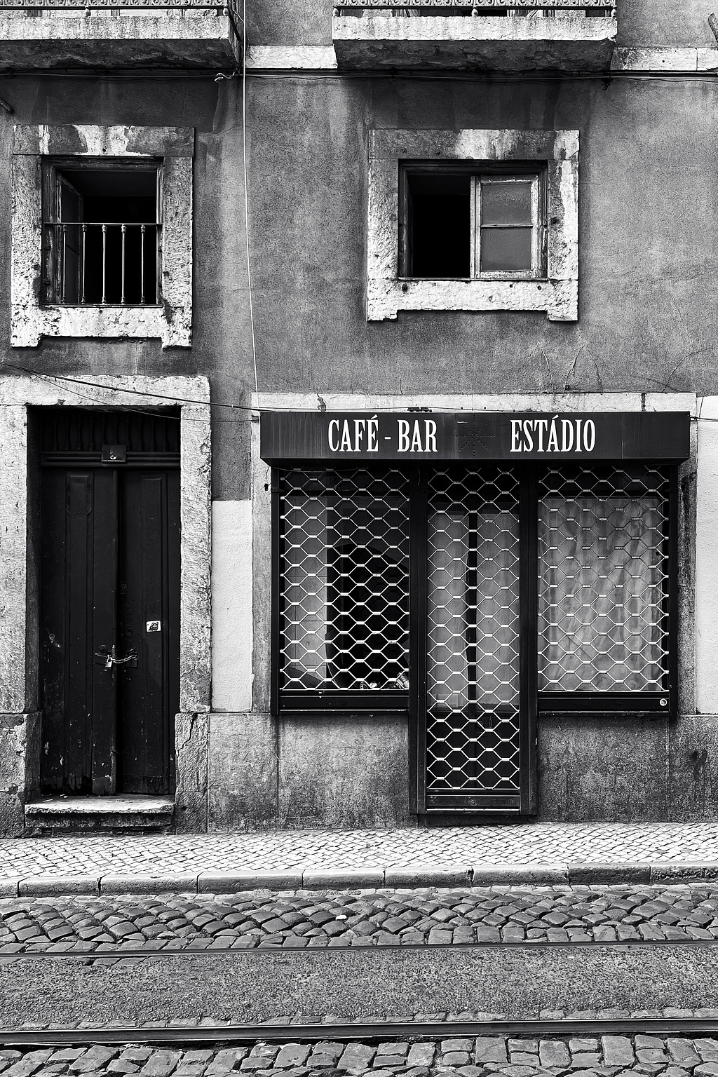 Shuttered shop, in an abandoned-looking building. 