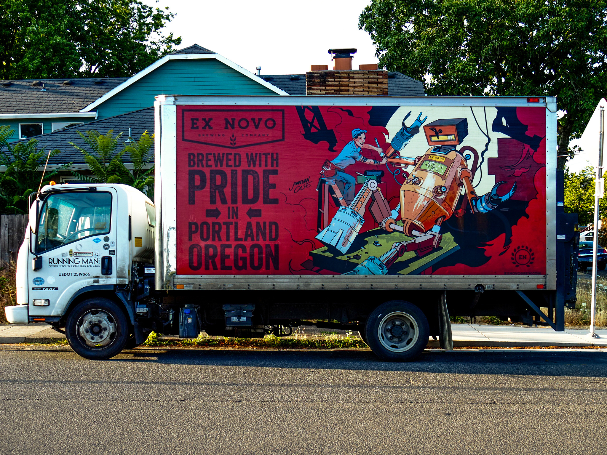 A panel truck with an illustration of a robot being operated on by a women in a "Rosie the Riveter" outfit. 