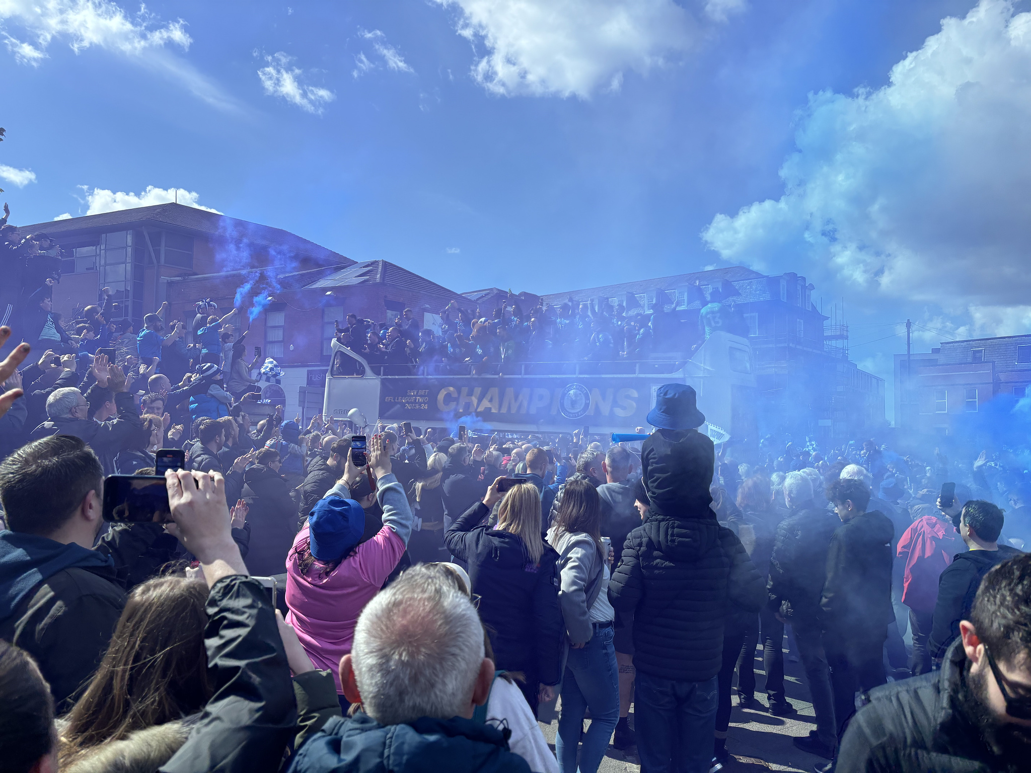 The open top bus with Stockport County players showing off their champions cup.