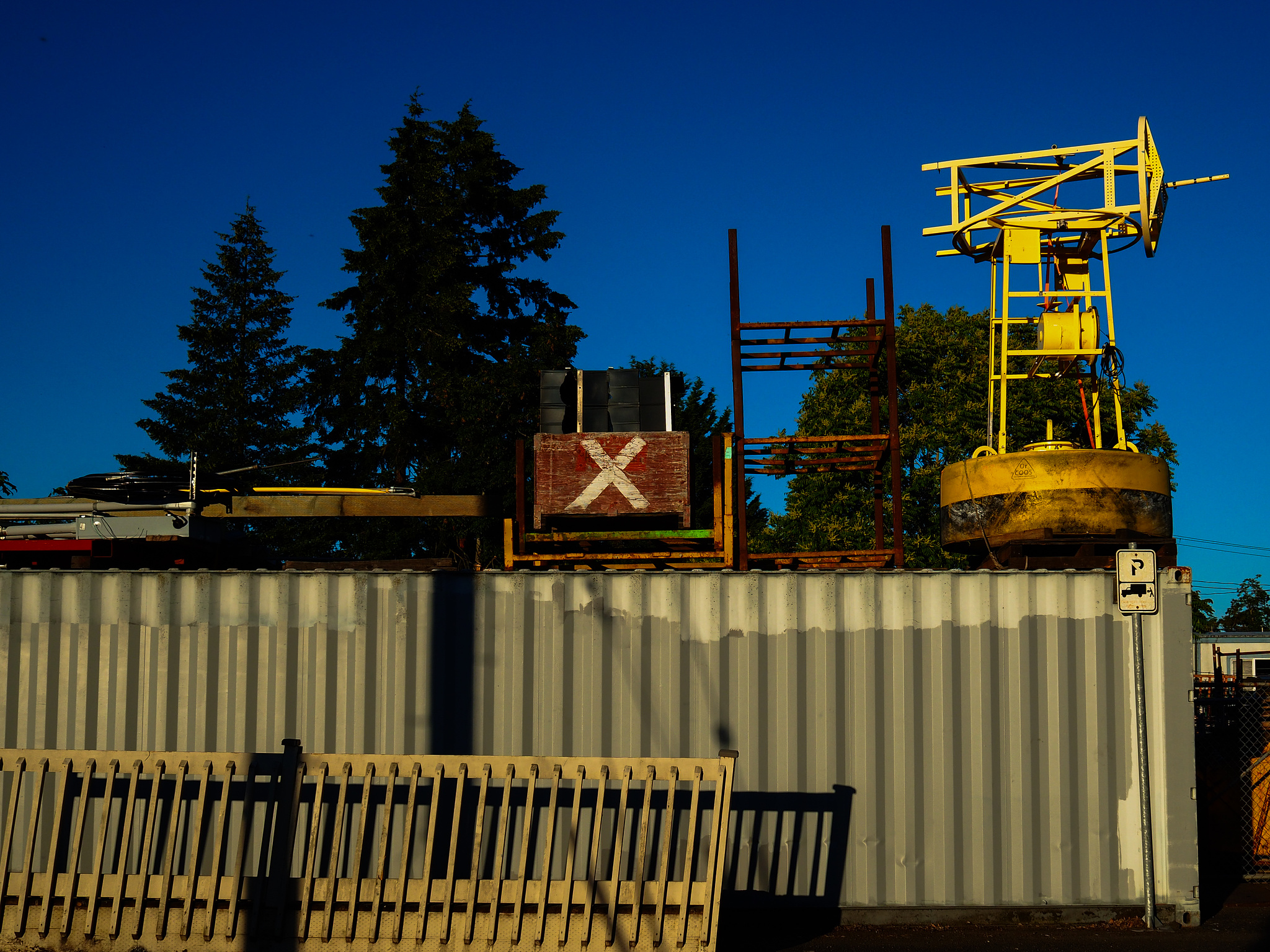 Shopping containers with a yellow metal construct on top. 