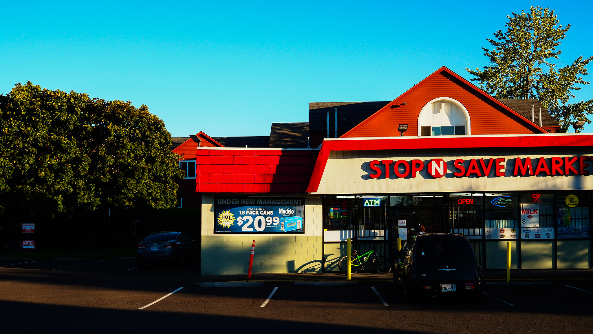 A Shop N Save Market with bright red trim in golden hour light. 