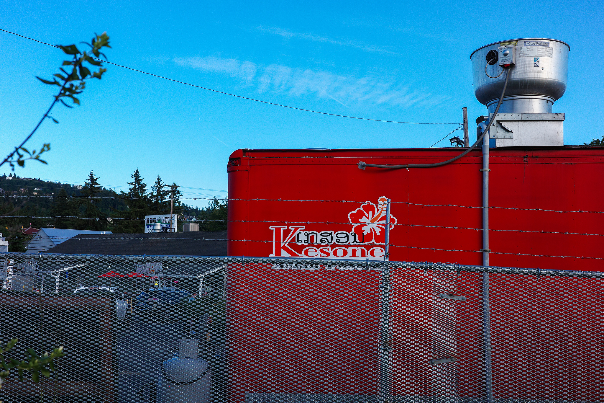 A bright red food cart against a bright blue sky. 