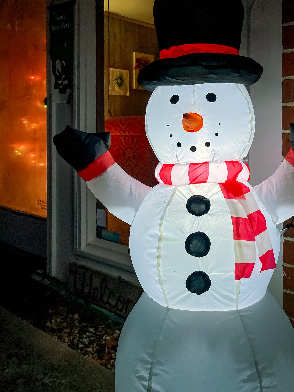 Inflatable Frosty the Snowman standing by the side door to our house.