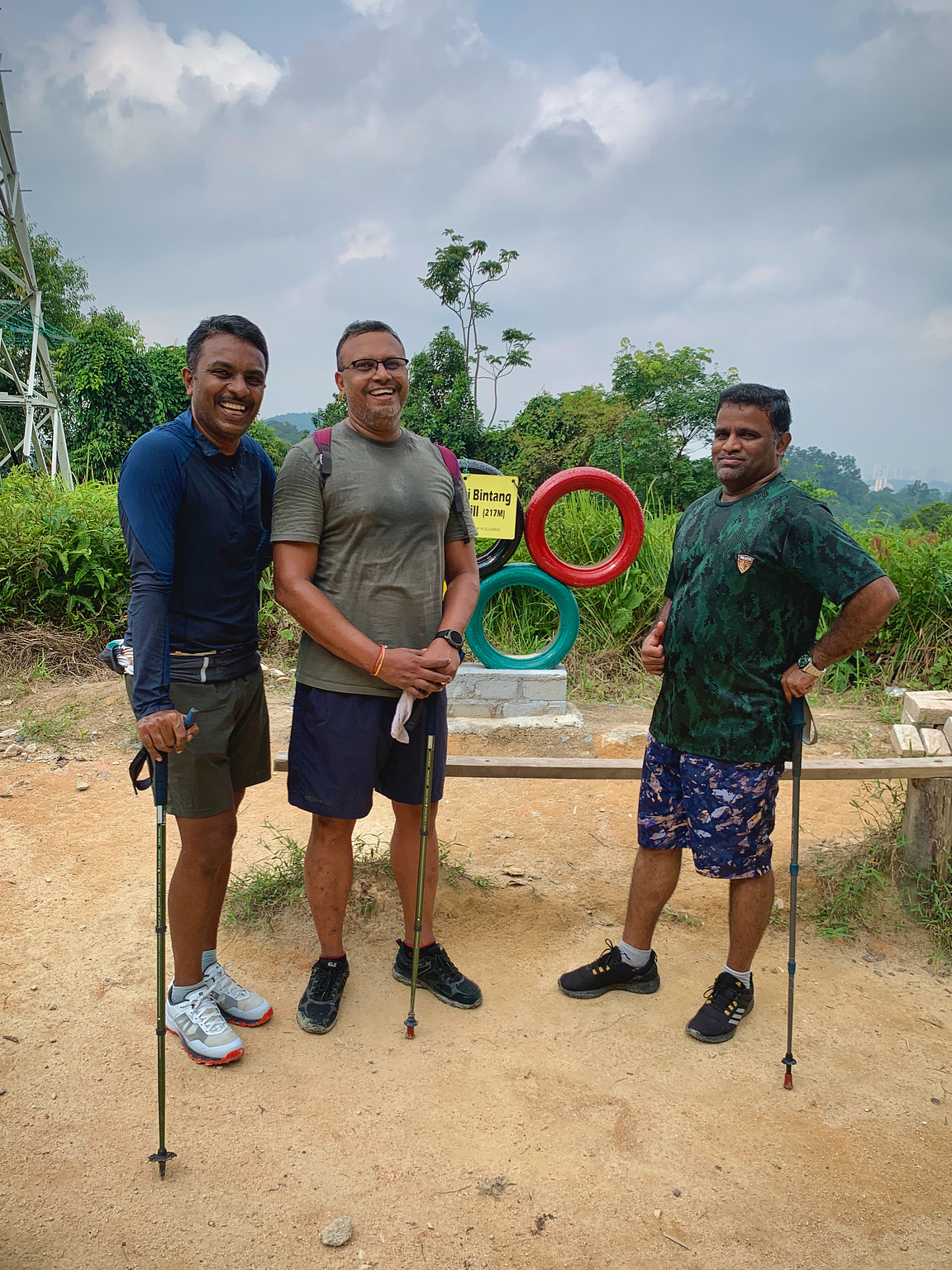 3 middle aged men at the top of a hill, smiling for a pic.