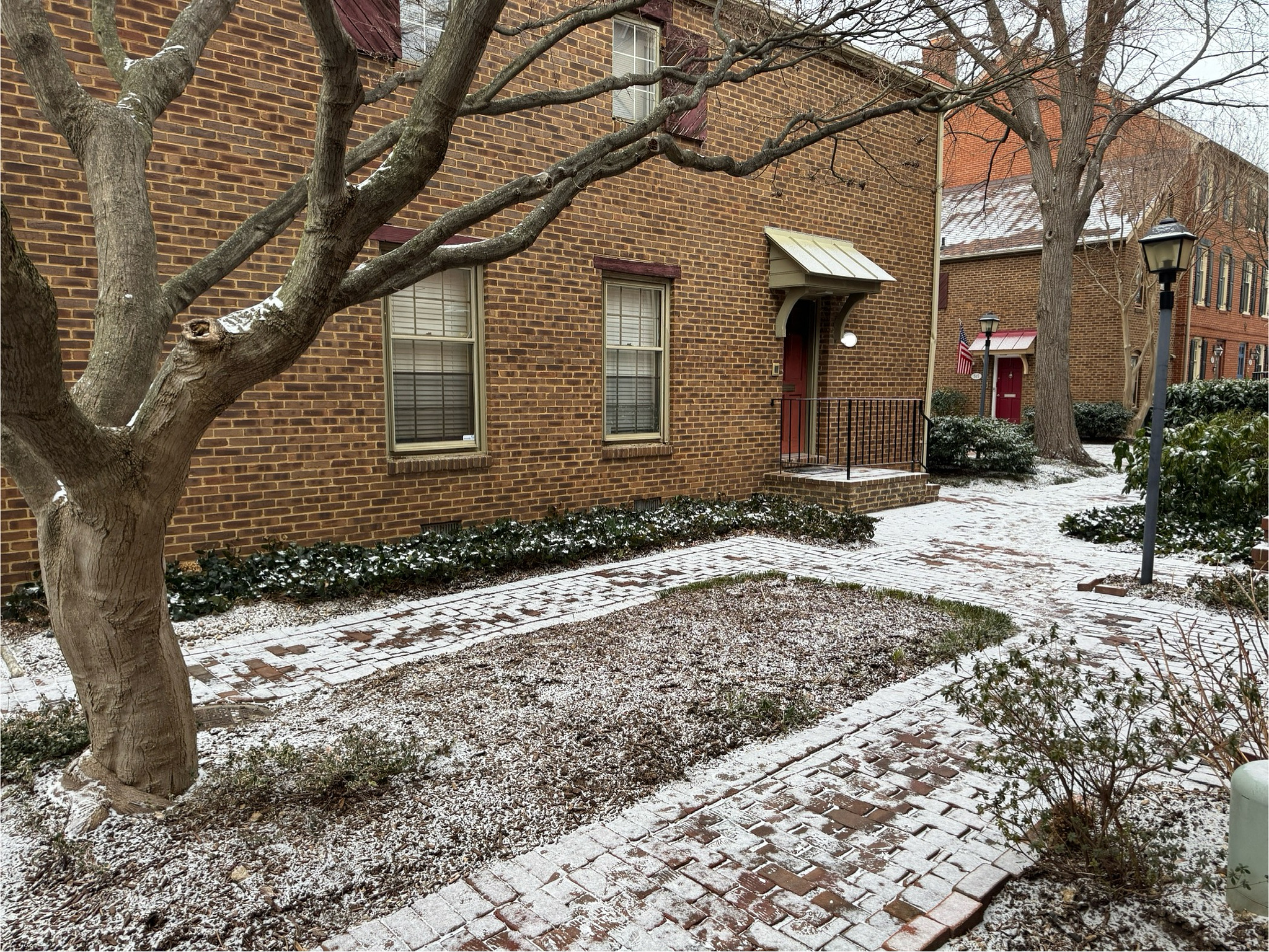 courtyard with a light dusting of snow covering the ground and tree