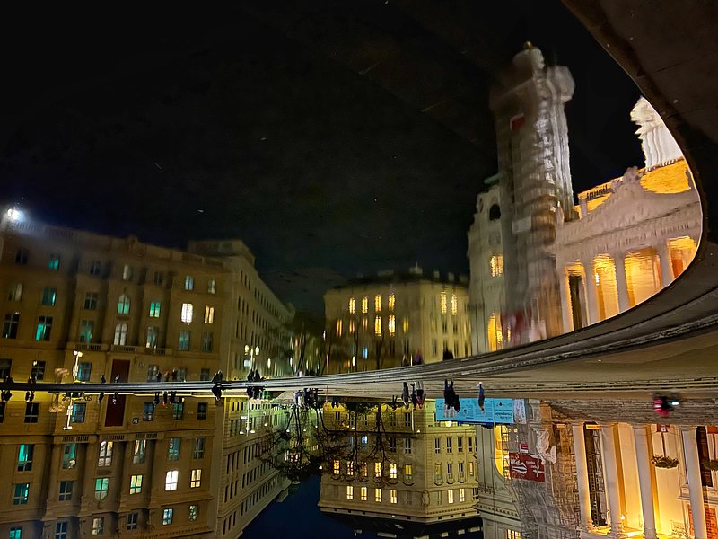 Buildings and a Part of the Karlskirche (Vienna, Austria), reflected in a small pond. Evening light - dark sky, light of lanterns. The Picture is turned upside down, 